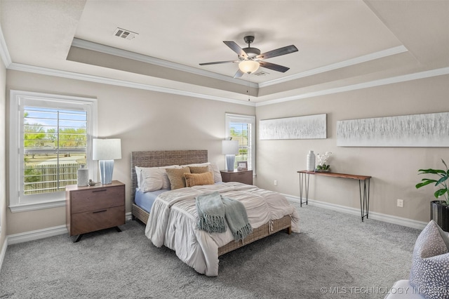 bedroom featuring carpet flooring, visible vents, ornamental molding, and a raised ceiling