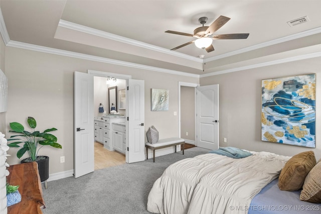 bedroom featuring a tray ceiling, light carpet, ornamental molding, and visible vents