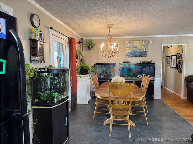 dining area with a notable chandelier, ornamental molding, and a textured ceiling