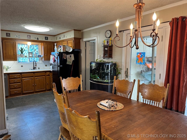 dining room featuring crown molding, sink, a notable chandelier, and a textured ceiling