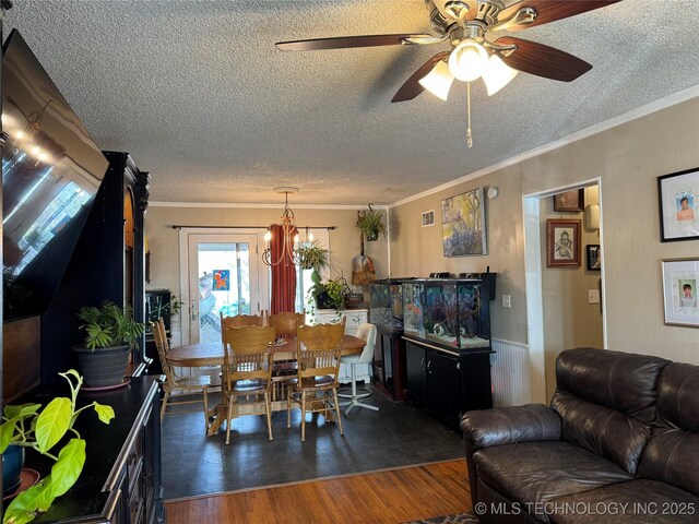 dining area with crown molding, dark hardwood / wood-style flooring, ceiling fan with notable chandelier, and a textured ceiling