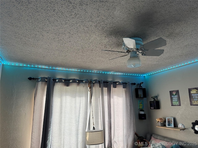 interior details featuring ceiling fan and a textured ceiling