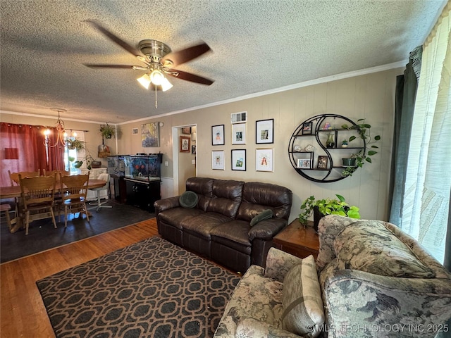 living room featuring ornamental molding, ceiling fan with notable chandelier, a textured ceiling, and dark hardwood / wood-style flooring