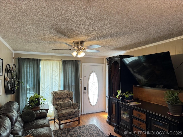 living room with ornamental molding, ceiling fan, and light hardwood / wood-style floors