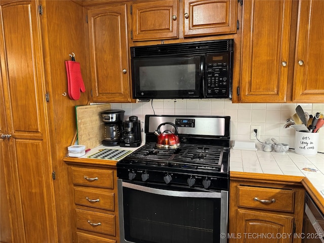 kitchen featuring tile counters, backsplash, and black appliances