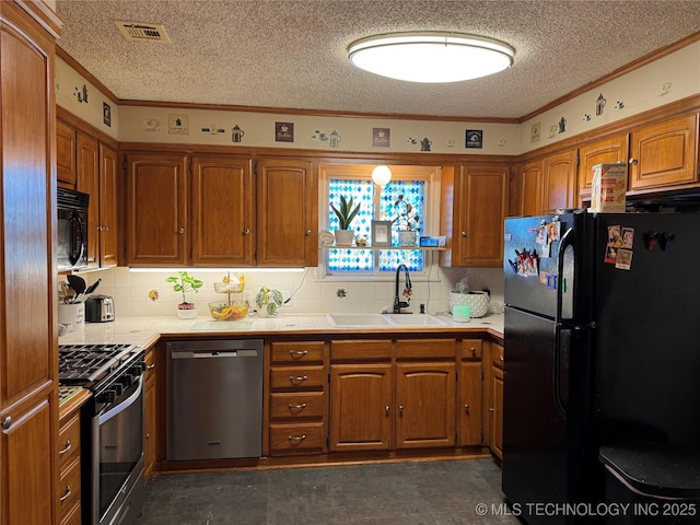 kitchen featuring tile countertops, sink, decorative backsplash, ornamental molding, and black appliances