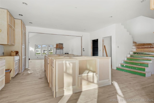 kitchen featuring light brown cabinetry, light hardwood / wood-style flooring, and a center island