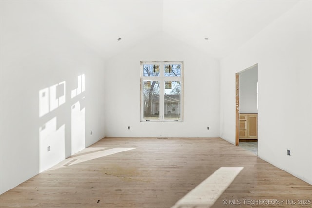 unfurnished living room featuring lofted ceiling and light wood-type flooring