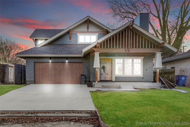 view of front of home with a garage, a yard, and covered porch