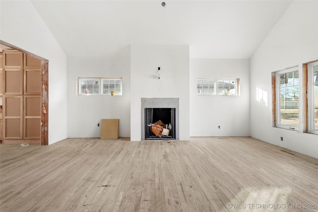 unfurnished living room with vaulted ceiling and light hardwood / wood-style flooring