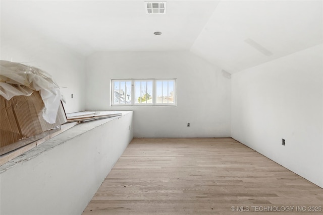 bonus room featuring lofted ceiling and light hardwood / wood-style flooring