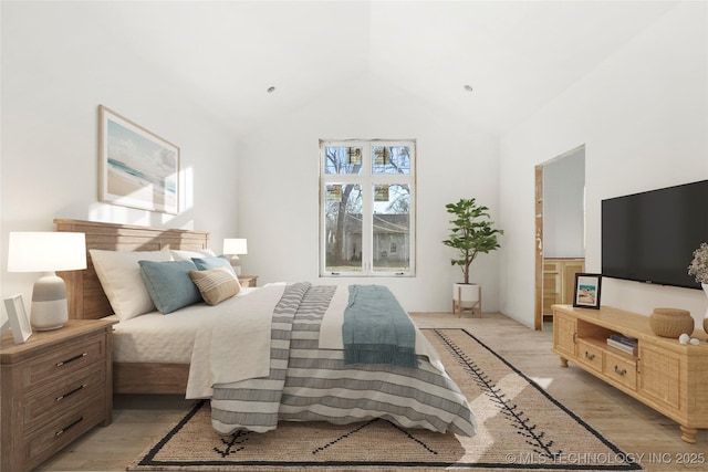 bedroom with lofted ceiling and light wood-type flooring