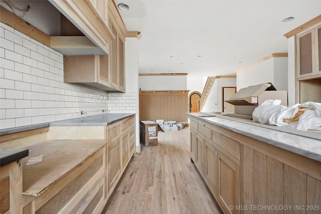 kitchen featuring light hardwood / wood-style floors, backsplash, light brown cabinets, and ornamental molding