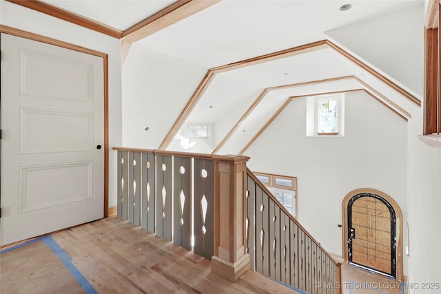 stairway with vaulted ceiling and hardwood / wood-style flooring