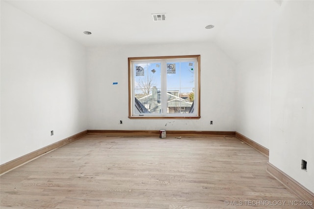 empty room featuring lofted ceiling and light wood-type flooring