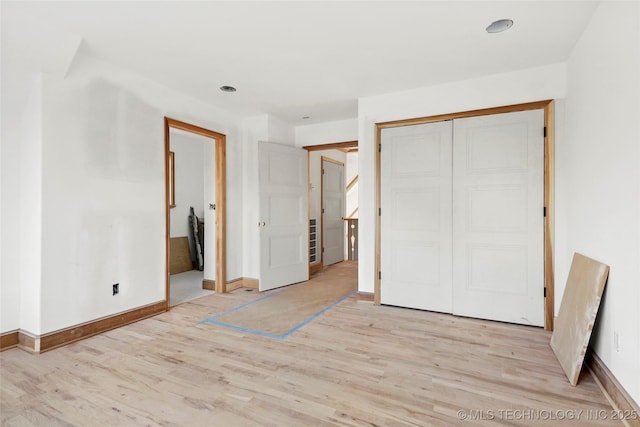 unfurnished bedroom with a closet and light hardwood / wood-style flooring