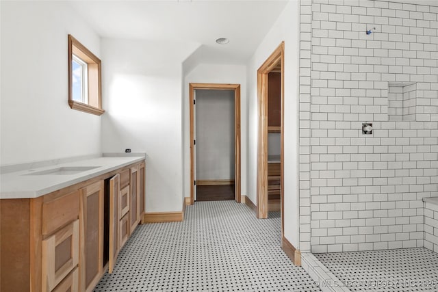 bathroom with vanity and tiled shower