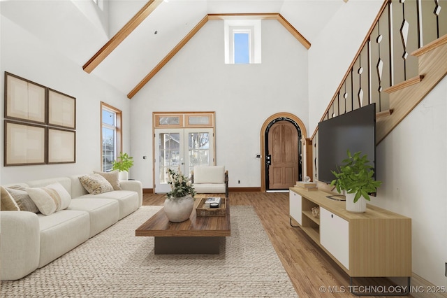 living room with high vaulted ceiling and light wood-type flooring