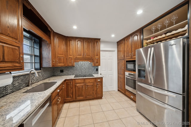 kitchen featuring tasteful backsplash, black appliances, sink, light tile patterned flooring, and light stone counters