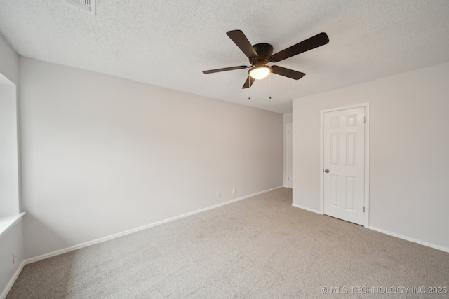 empty room with ceiling fan, a textured ceiling, and carpet flooring