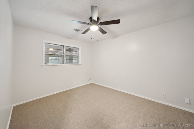 empty room featuring ceiling fan, carpet, and a textured ceiling