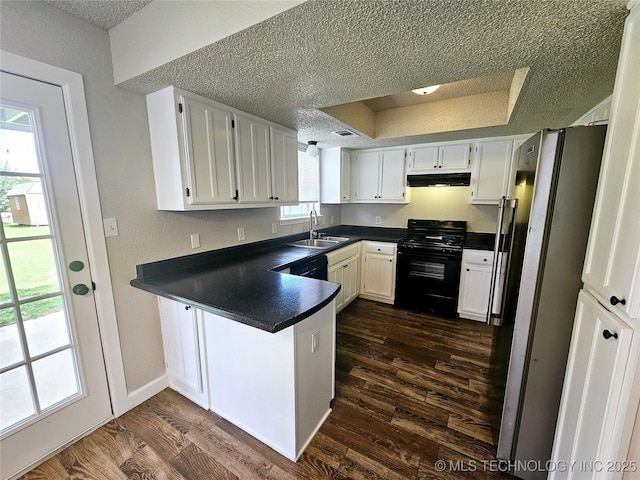 kitchen with stainless steel fridge, white cabinets, kitchen peninsula, and gas stove