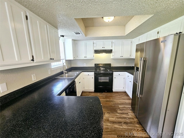 kitchen with sink, white cabinets, black appliances, and a raised ceiling