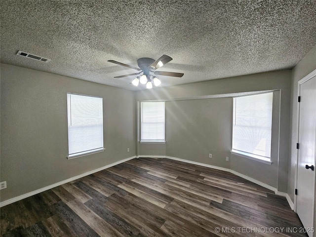 empty room with ceiling fan, a healthy amount of sunlight, and dark hardwood / wood-style floors