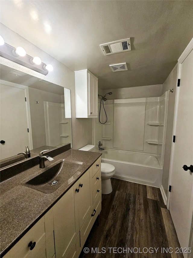 full bathroom featuring toilet, vanity, wood-type flooring, and washtub / shower combination