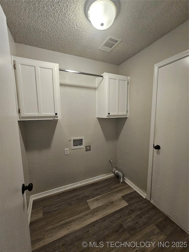 laundry room with dark wood-type flooring, cabinets, a textured ceiling, and hookup for a washing machine