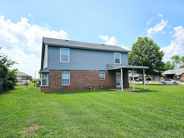 rear view of property with cooling unit, a lawn, and a patio