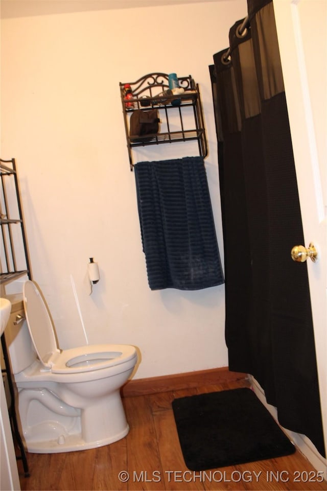 bathroom with toilet and wood-type flooring