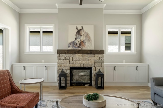 sitting room with light wood-type flooring, ornamental molding, and a healthy amount of sunlight