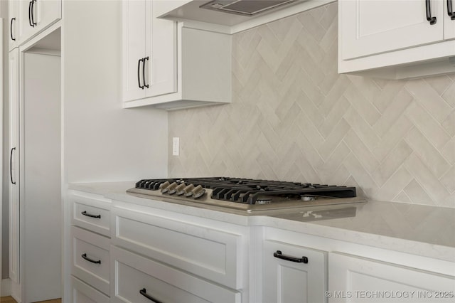 kitchen featuring light stone countertops and white cabinets