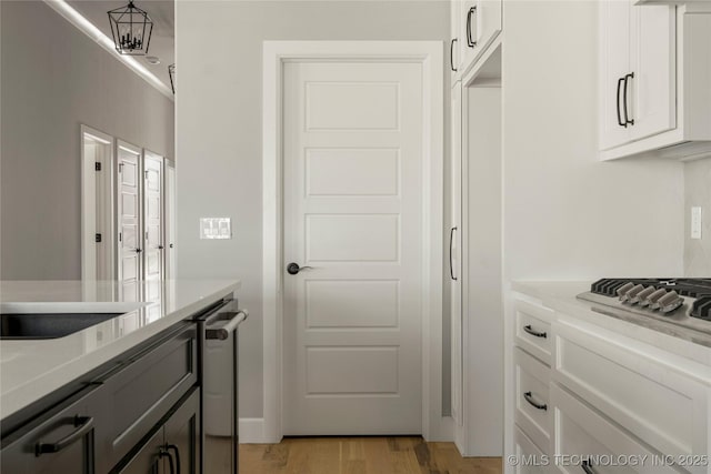 kitchen with white cabinets, stainless steel gas cooktop, and light hardwood / wood-style floors