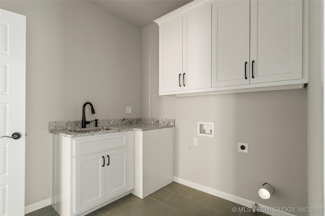 clothes washing area featuring sink, dark tile patterned floors, washer hookup, hookup for an electric dryer, and cabinets