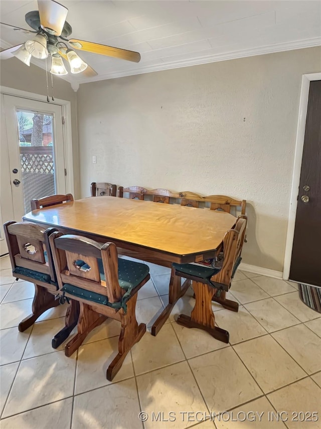 tiled dining room with ceiling fan and ornamental molding