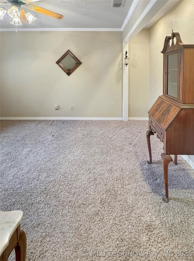 misc room featuring ceiling fan, a textured ceiling, crown molding, and carpet flooring