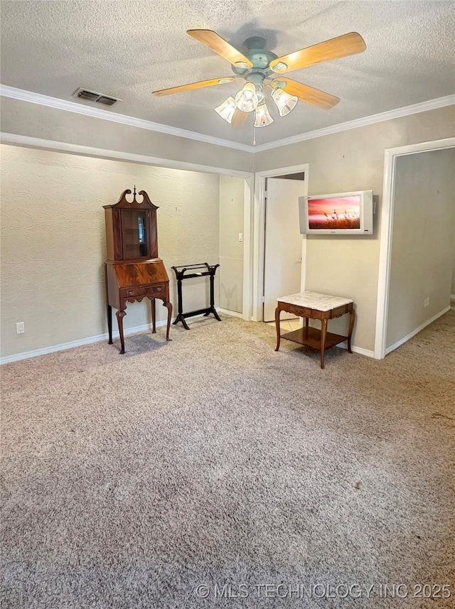 sitting room featuring a textured ceiling, ceiling fan, ornamental molding, and carpet