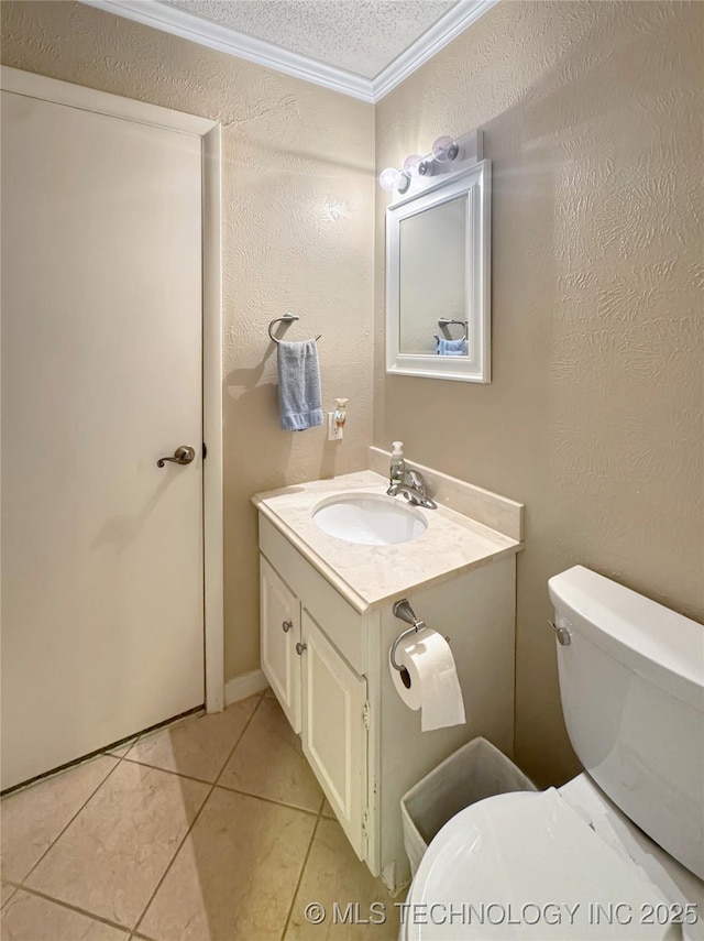 bathroom with toilet, tile patterned floors, a textured ceiling, ornamental molding, and vanity