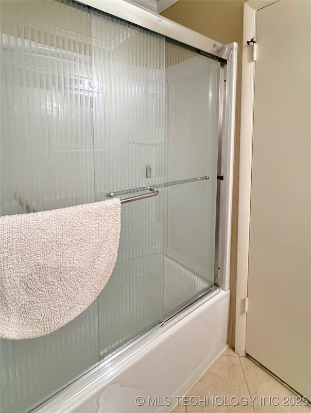 bathroom featuring enclosed tub / shower combo and tile patterned flooring