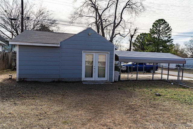 view of outdoor structure featuring french doors, a carport, and a yard