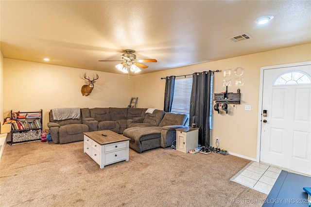 living room featuring ceiling fan, light colored carpet, and a healthy amount of sunlight