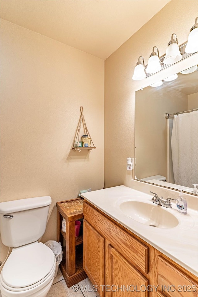 bathroom with toilet, tile patterned flooring, and vanity