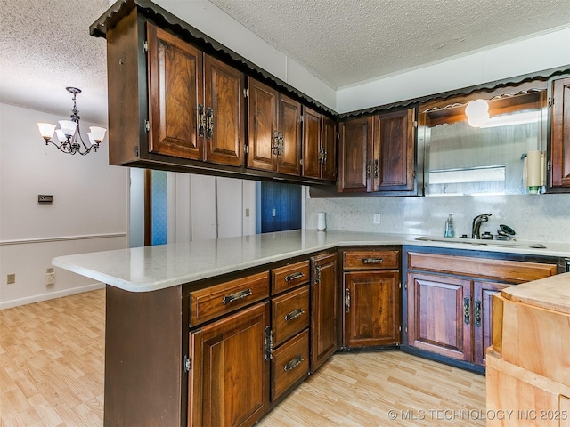 kitchen featuring sink, pendant lighting, kitchen peninsula, and a textured ceiling