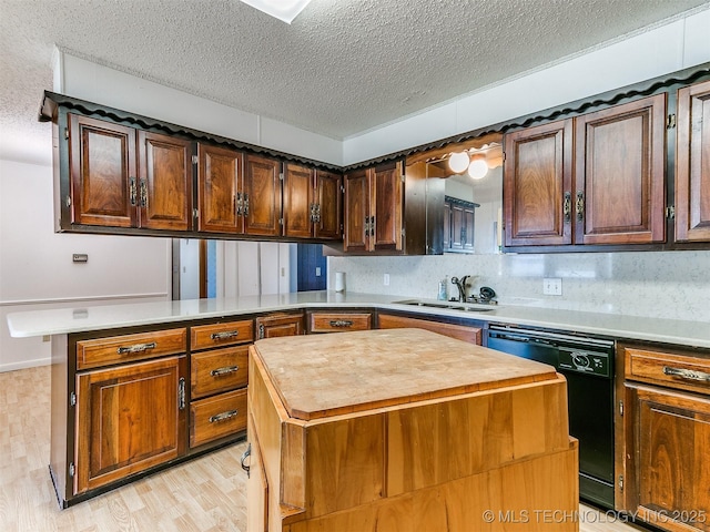 kitchen featuring dishwasher, kitchen peninsula, a center island, and sink