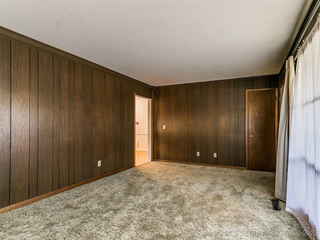 carpeted empty room with a textured ceiling