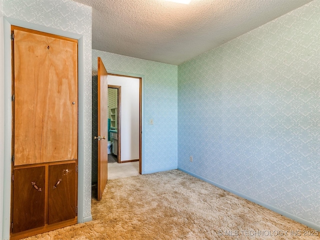 carpeted spare room featuring a textured ceiling