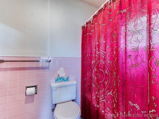 bathroom with tile walls and toilet