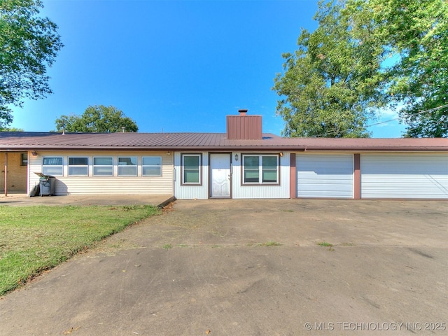 ranch-style home with a garage and a front lawn